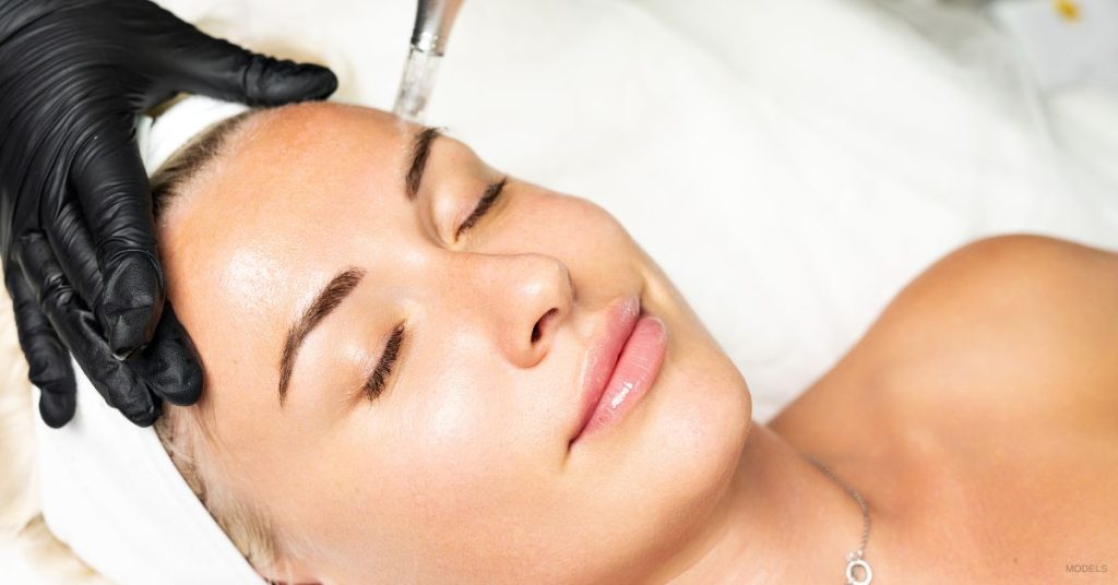 A woman getting a facial treatment at a spa. (Models)