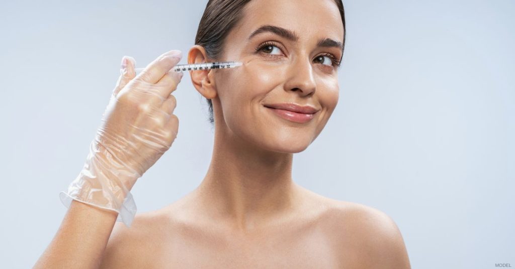 Woman receiving HArmonyCa® dermal filler injection on the face (model)